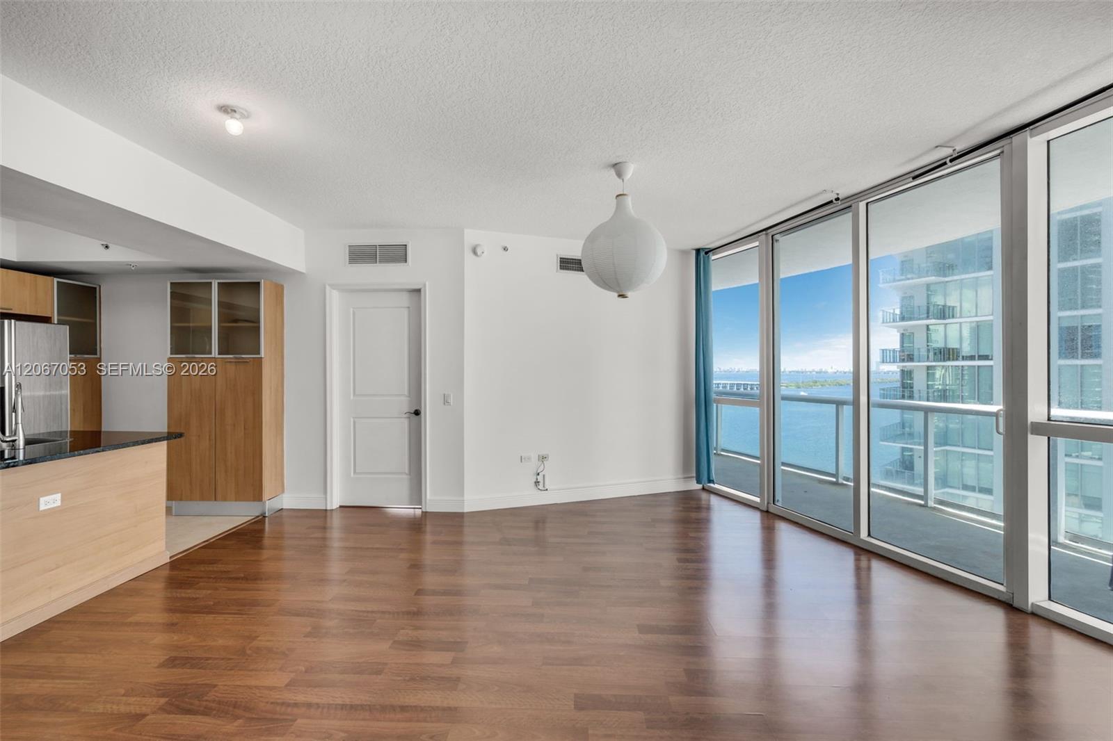 Living area of unit 1701 with floor-to-ceiling glass and bay views