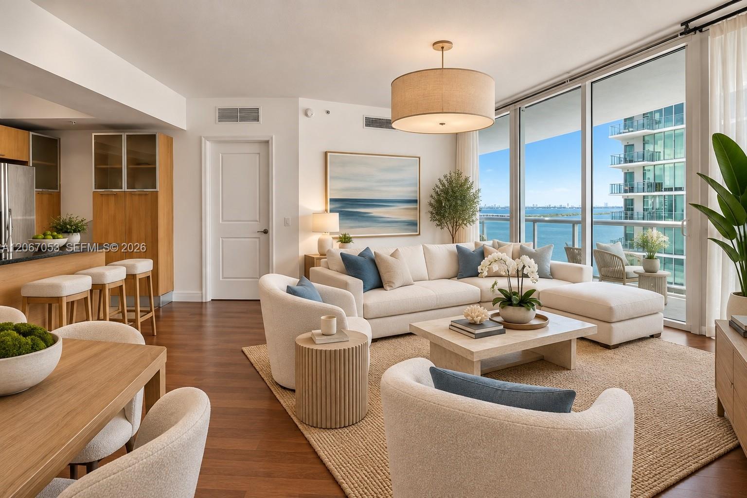 Living and dining area of unit 1701, virtually staged, with the bay beyond the balcony