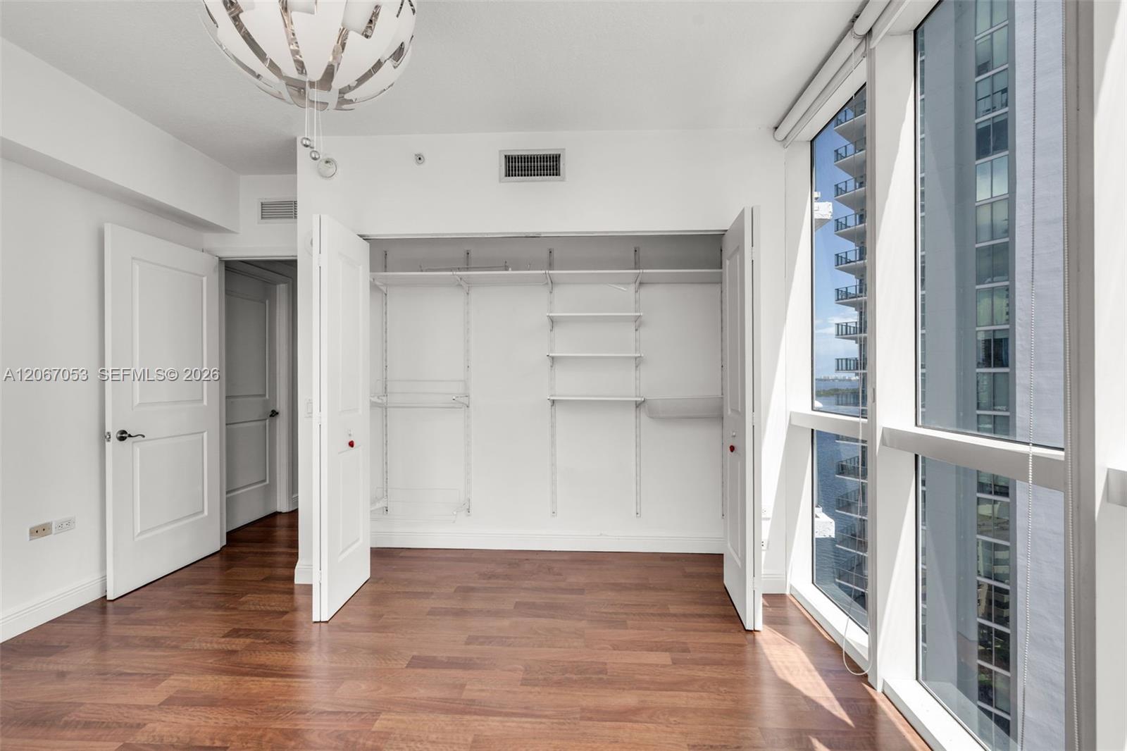 Den with fitted closet and floor-to-ceiling window