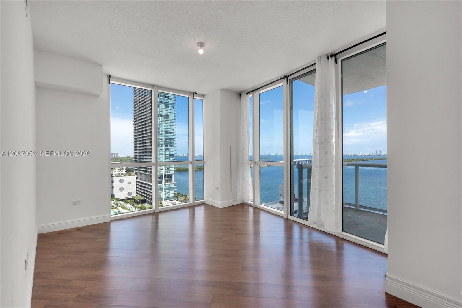 Primary bedroom unfurnished with bay view and balcony access